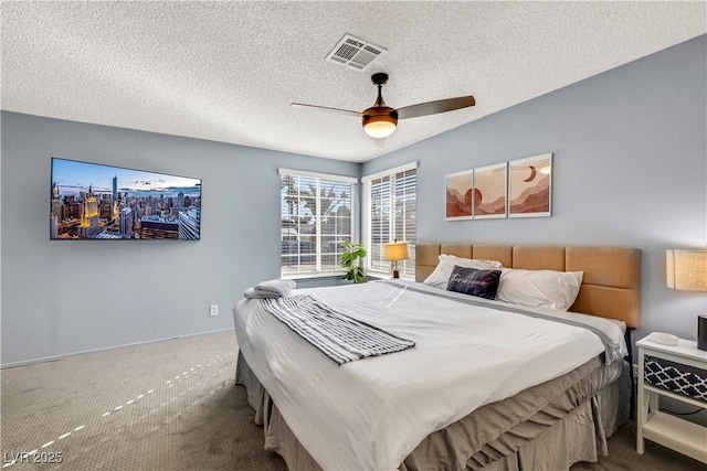 bedroom with a textured ceiling, ceiling fan, carpet flooring, and visible vents