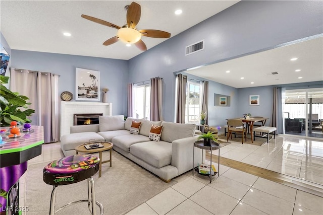 living area with light tile patterned flooring, recessed lighting, a fireplace, a ceiling fan, and visible vents