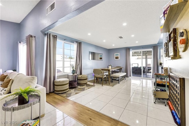 interior space with light tile patterned floors, a wealth of natural light, visible vents, and recessed lighting