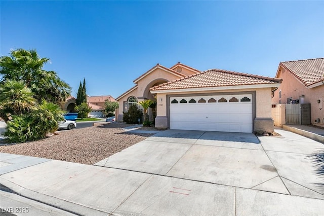 view of front of property with a garage, driveway, a tile roof, and stucco siding