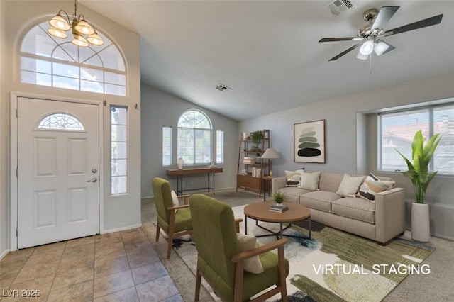 living area with ceiling fan with notable chandelier, visible vents, vaulted ceiling, and light tile patterned floors