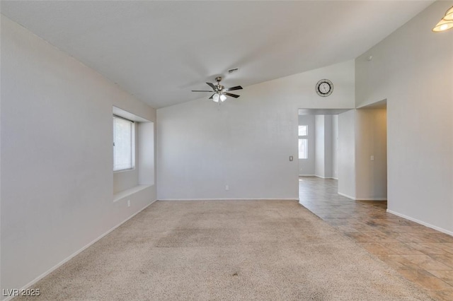 spare room featuring a ceiling fan, lofted ceiling, a healthy amount of sunlight, and carpet