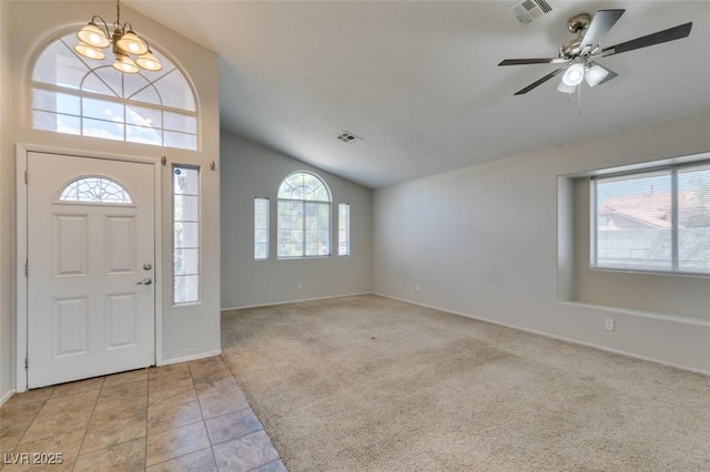 foyer entrance featuring a wealth of natural light, visible vents, and light colored carpet