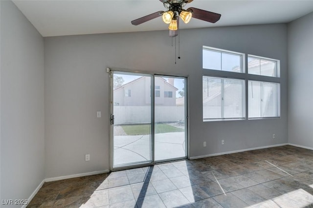 spare room featuring a ceiling fan, lofted ceiling, and baseboards