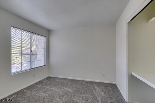 carpeted empty room with baseboards