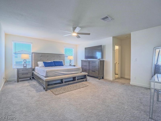 bedroom with visible vents, light colored carpet, baseboards, and ceiling fan