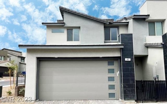 exterior space with decorative driveway and fence