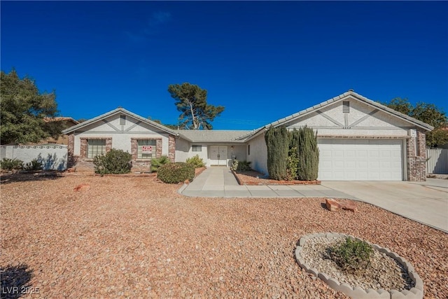 single story home featuring concrete driveway, brick siding, an attached garage, and fence