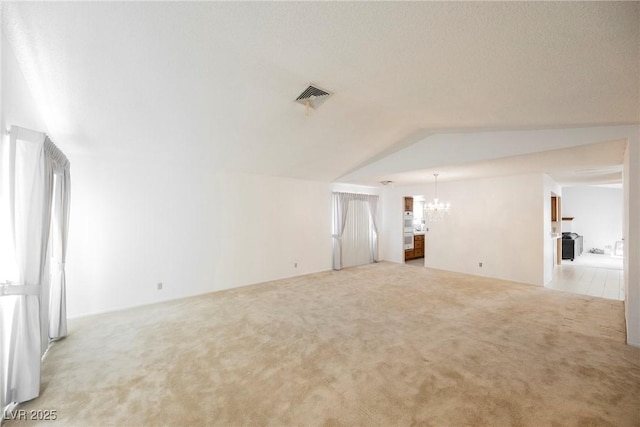 interior space with lofted ceiling, carpet flooring, visible vents, and an inviting chandelier