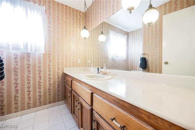 bathroom with tile patterned flooring, vanity, baseboards, and wallpapered walls