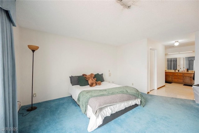 bedroom with light colored carpet and connected bathroom