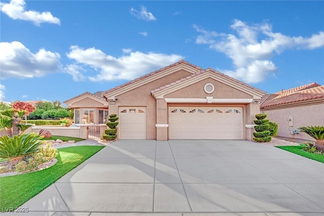 view of front facade featuring driveway, a tiled roof, an attached garage, and stucco siding