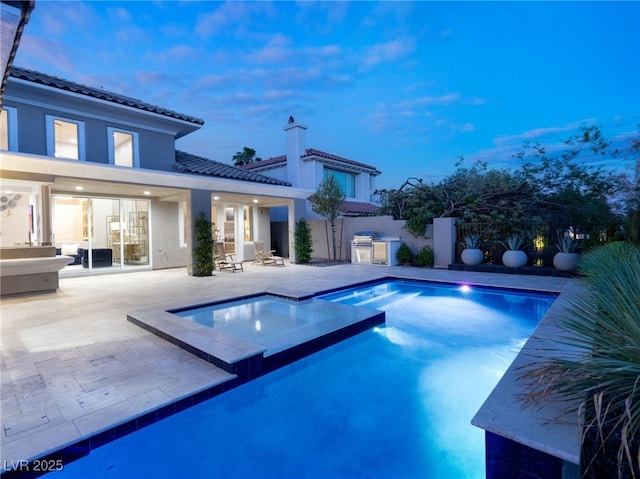 view of pool with a pool with connected hot tub, a patio, area for grilling, and fence