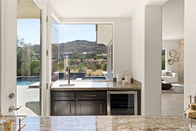 bar featuring wine cooler, a sink, and a mountain view