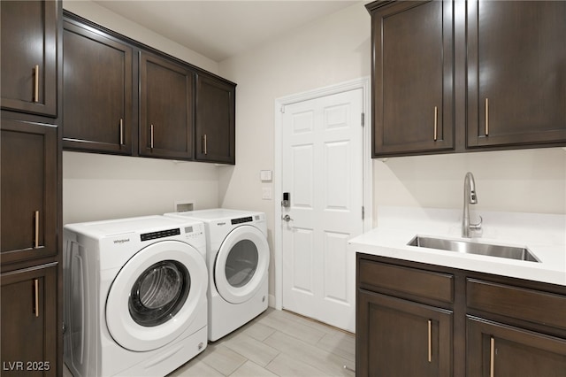 laundry room featuring washer and clothes dryer, a sink, and cabinet space