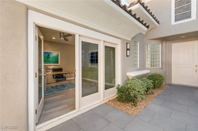 entrance to property featuring a tiled roof and stucco siding