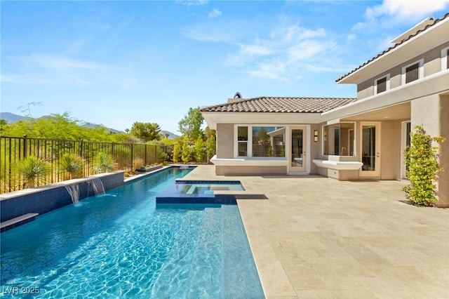 view of pool with a fenced backyard, a pool with connected hot tub, and a patio