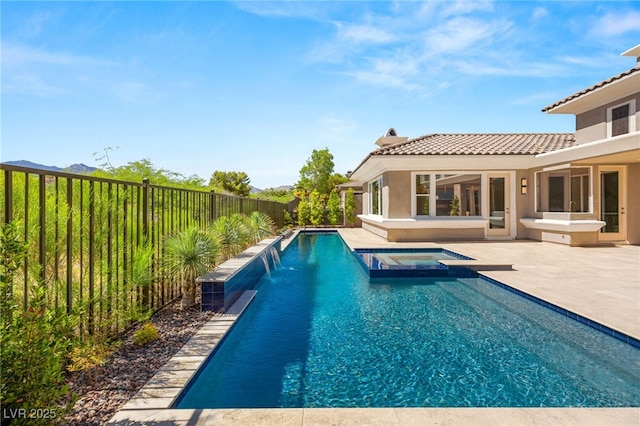 view of pool with a pool with connected hot tub, a fenced backyard, and a patio