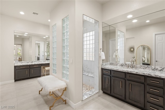 bathroom with baseboards, two vanities, a sink, and recessed lighting