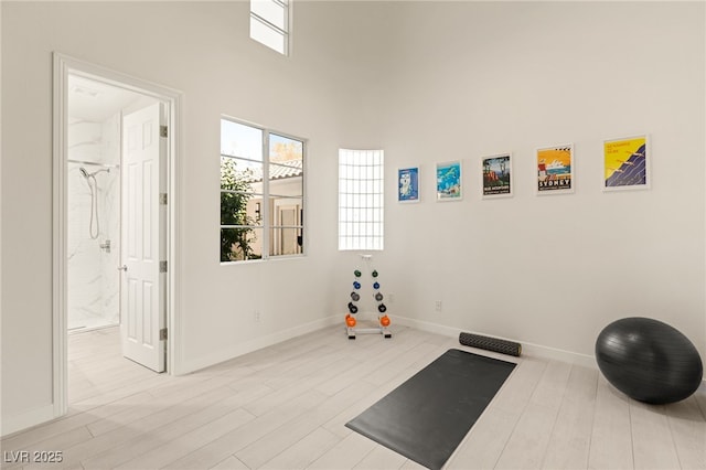 exercise room with baseboards and wood finished floors