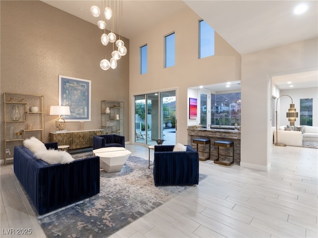 living room with a notable chandelier, baseboards, and wood finished floors