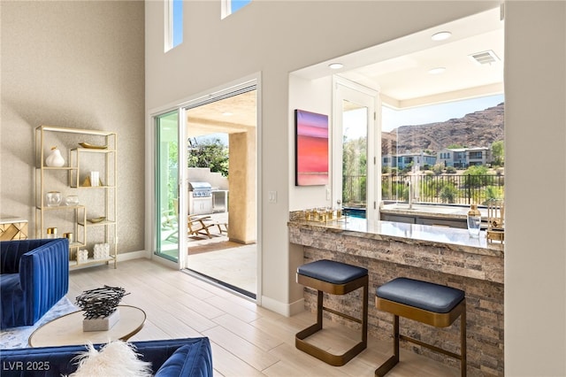 doorway to outside with baseboards, visible vents, a mountain view, and wood finished floors