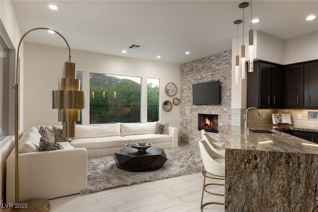 living room featuring recessed lighting, visible vents, and a fireplace