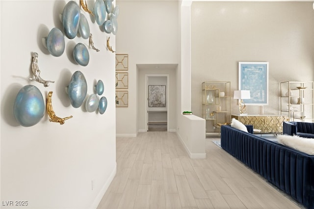 hallway featuring baseboards and light wood-style floors