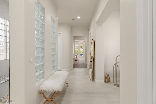 hall featuring light tile patterned floors, visible vents, baseboards, and recessed lighting