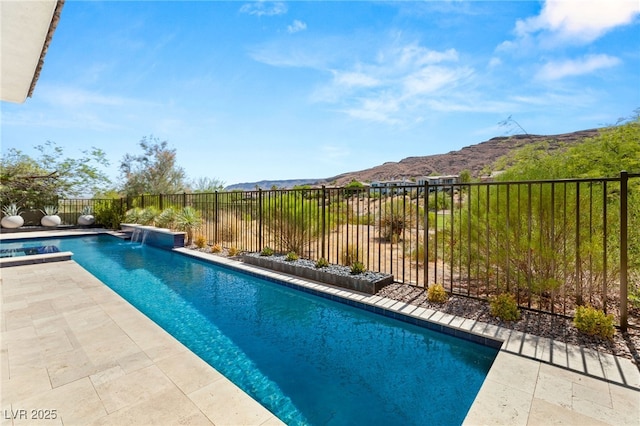 view of pool featuring a patio, a fenced backyard, a mountain view, and a fenced in pool