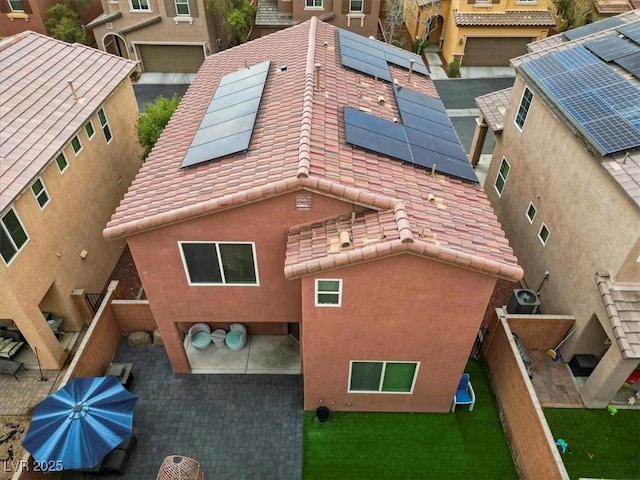 exterior space featuring solar panels, a tile roof, and stucco siding