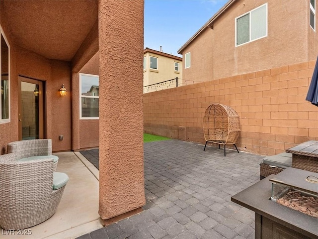 view of patio with an outdoor fire pit and fence