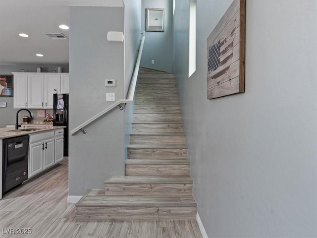 staircase featuring recessed lighting, visible vents, baseboards, and wood finished floors