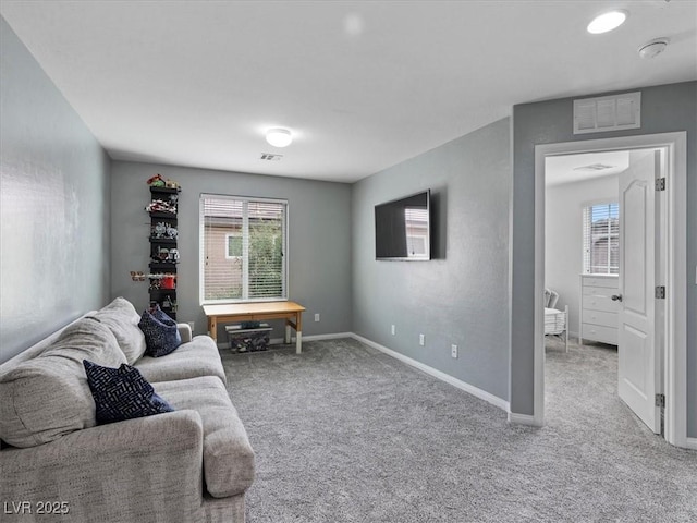 living area featuring baseboards, visible vents, and carpet flooring