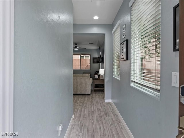 hallway featuring baseboards and wood finished floors