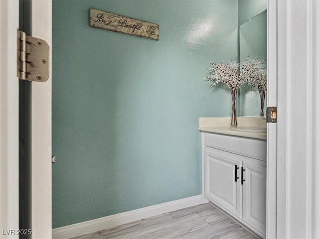 bathroom with vanity, baseboards, and wood finished floors