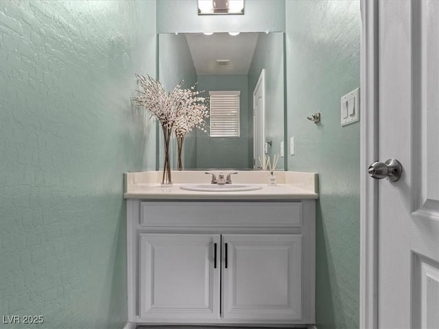 bathroom with vanity and a textured wall