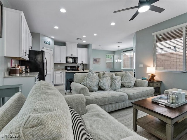 living room with light wood-style floors, recessed lighting, visible vents, and a ceiling fan