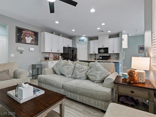 living room with light wood-style floors, recessed lighting, visible vents, and a ceiling fan