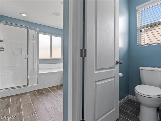 full bathroom with a stall shower, visible vents, baseboards, toilet, and a bath