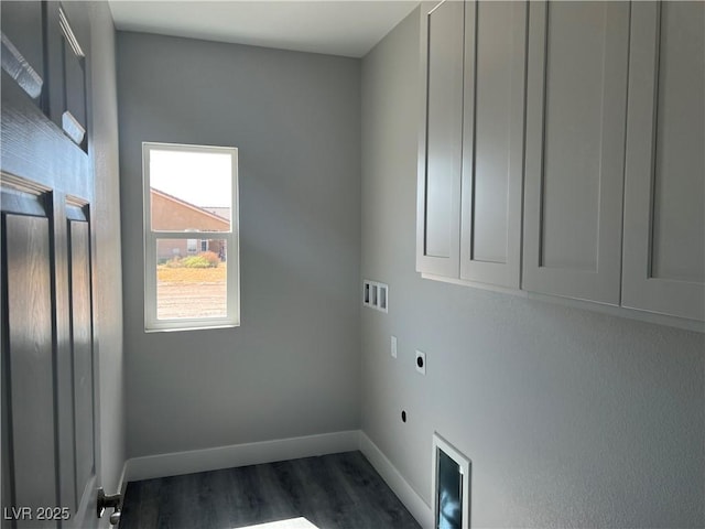 clothes washing area featuring dark wood-style flooring, hookup for a washing machine, cabinet space, electric dryer hookup, and baseboards