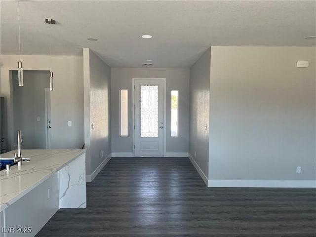 foyer entrance featuring dark wood-style flooring and baseboards