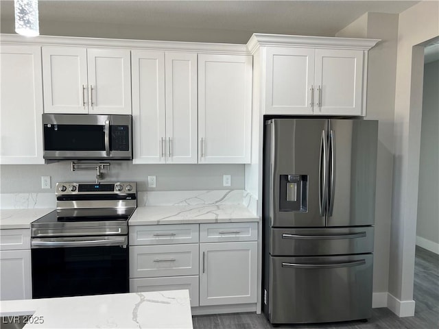 kitchen featuring baseboards, white cabinetry, stainless steel appliances, and light stone counters