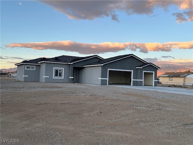 view of front of house with a garage, driveway, and stucco siding