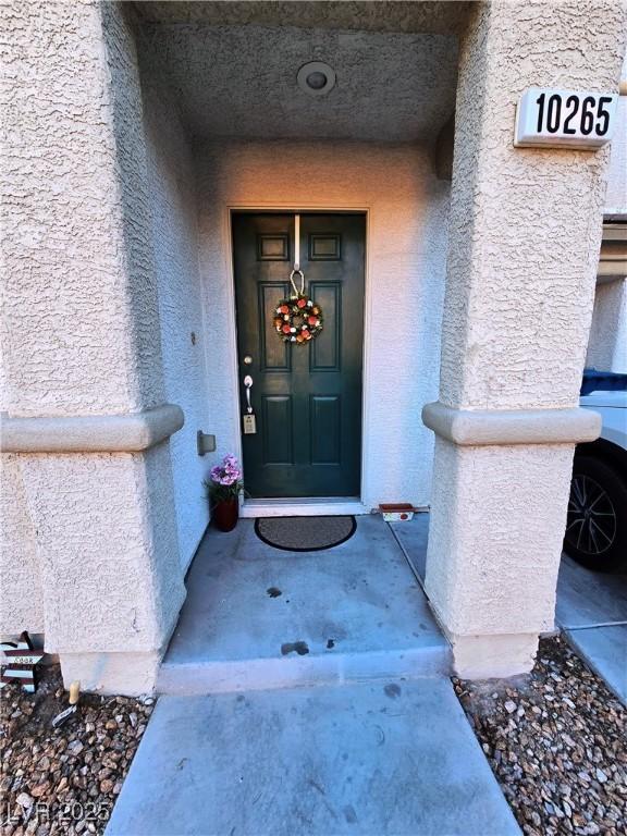 entrance to property featuring stucco siding