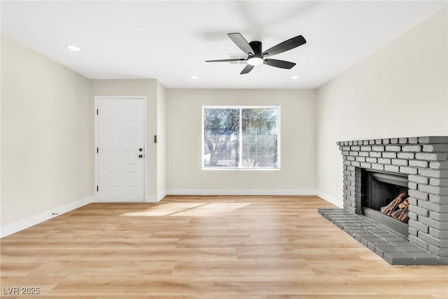 unfurnished living room with light wood-style floors, a fireplace, baseboards, and recessed lighting