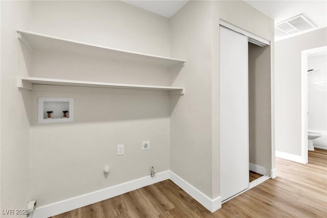 laundry area featuring hookup for a gas dryer, washer hookup, wood finished floors, visible vents, and electric dryer hookup