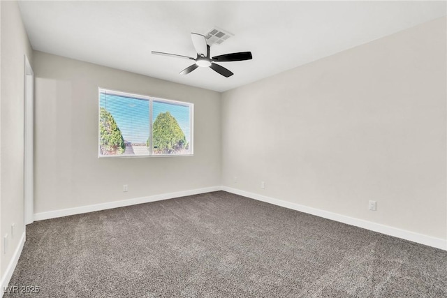 spare room featuring a ceiling fan, dark colored carpet, visible vents, and baseboards