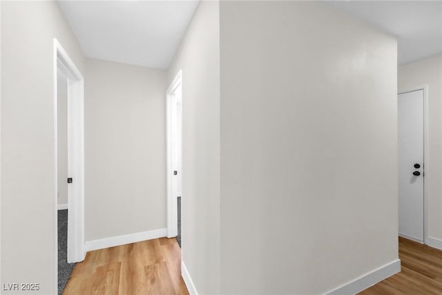 hall featuring light wood-style floors and baseboards