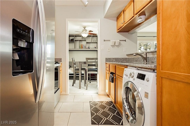 washroom with washer / dryer, light tile patterned floors, laundry area, a ceiling fan, and a sink